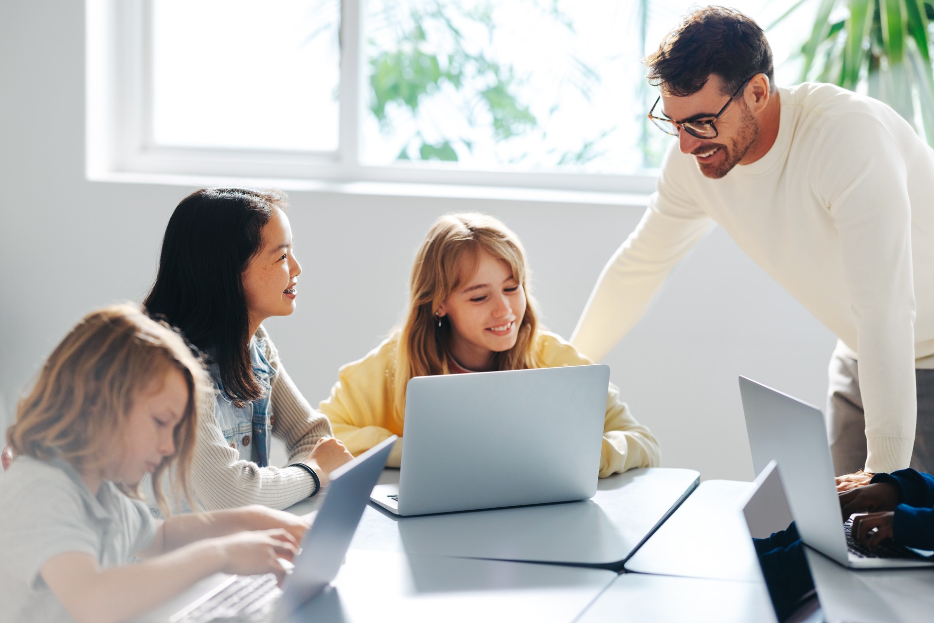 Computer-based learning in an elementary school: Teacher guiding a group of students in a coding class